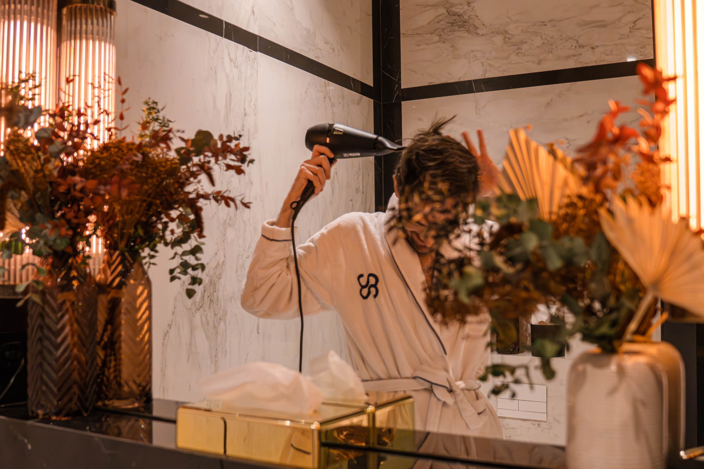 Marko Tadić (Mr.M) in the luxury bathroom in the Master Suite at the CoolRooms Palacio de Atocha Hotel with marble cladding and rain shower