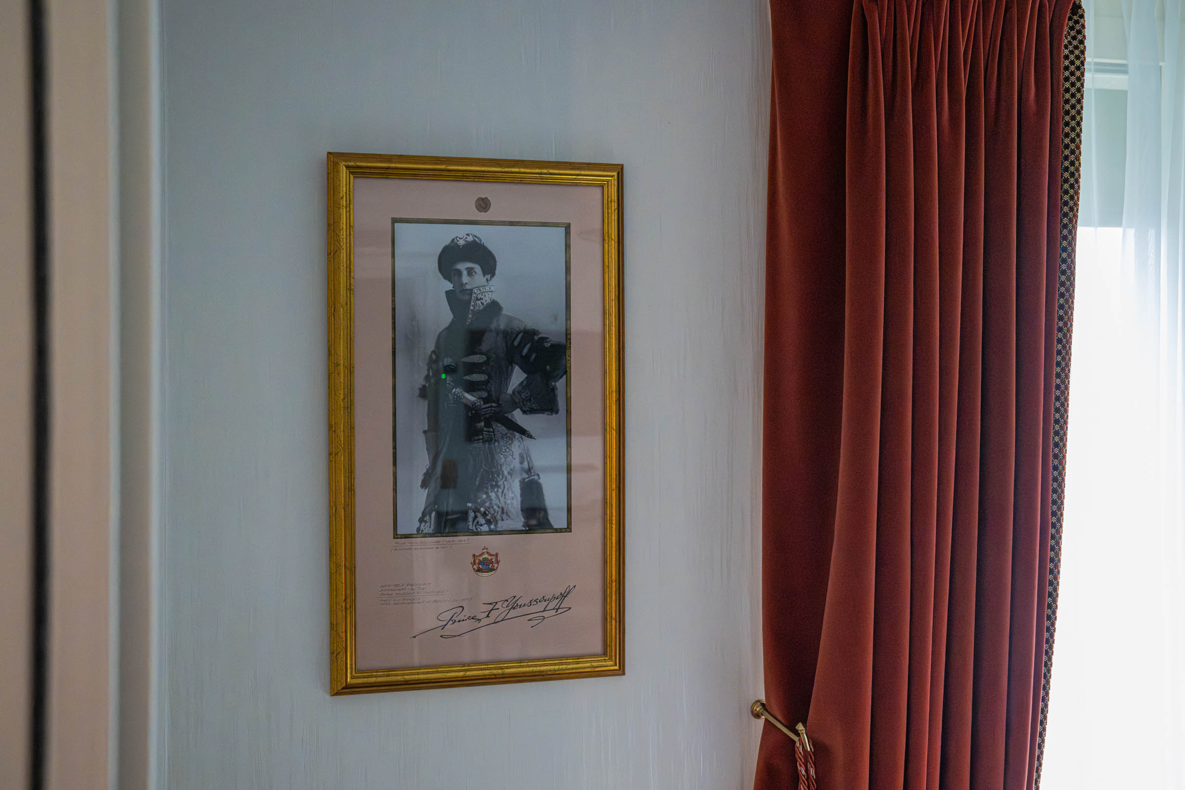 Signed black-and-white portrait of Prince Felix Youssoupov in a gilded frame beside rust velvet curtains at Hôtel Napoléon Paris, photo by Marko Tadić, founder of Mr.M by Marko Tadić blog