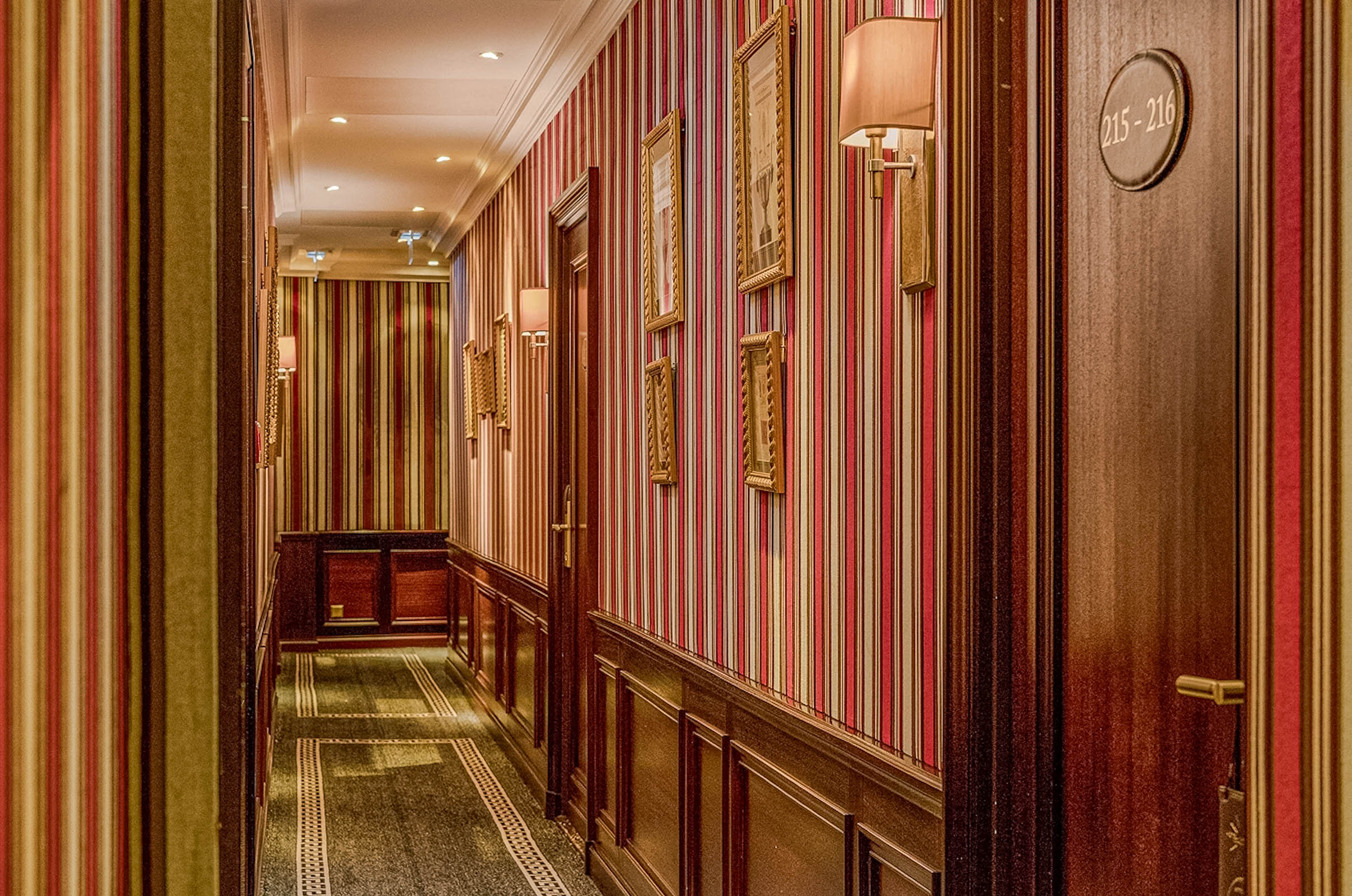 Striped corridor at Hôtel Napoléon Paris with mahogany wainscoting, framed prints and brass wall sconces, photo by Marko Tadić, founder of Mr.M by Marko Tadić blog