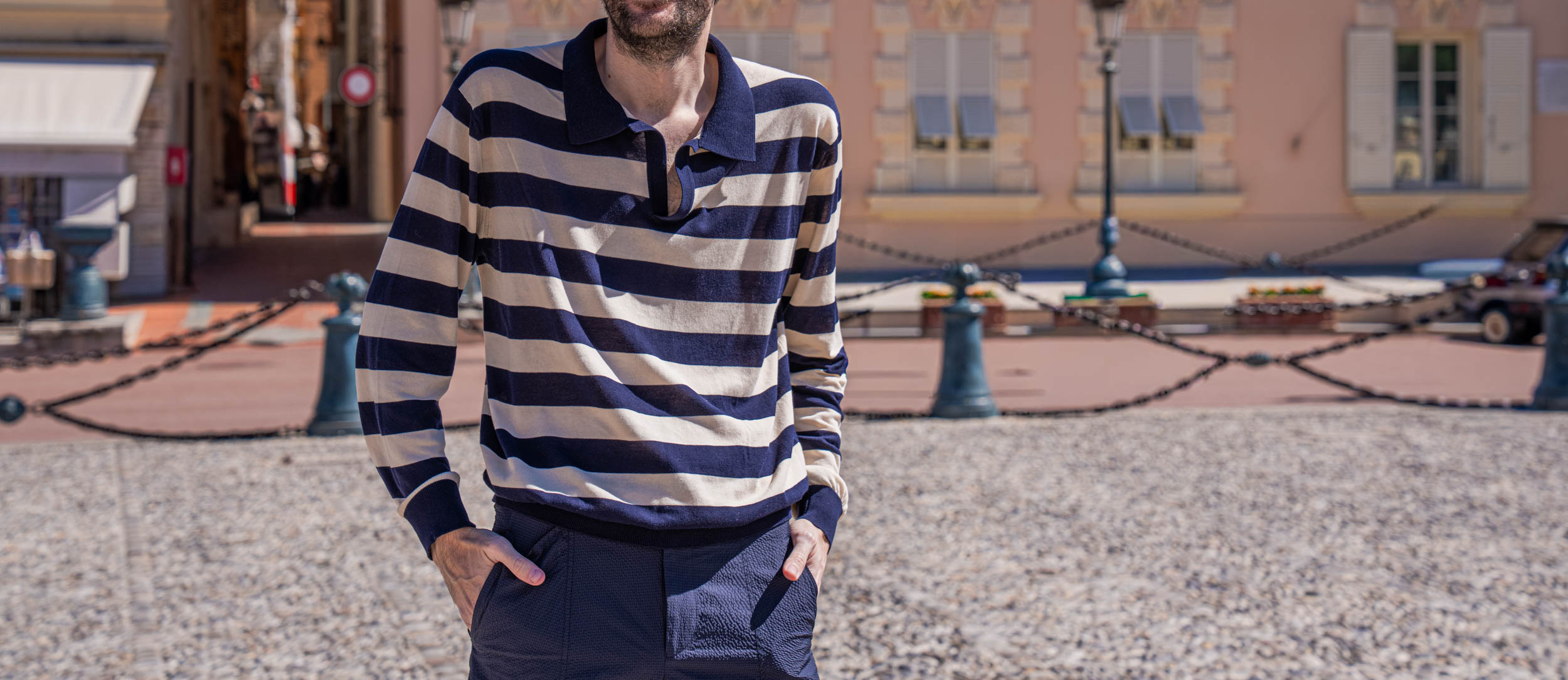 Elegant spring look of Marko Tadić, founder of the Mr.M blog, in a FERRAGAMO knit polo and cargo trousers beside the arched loggias and grand entrance of the Prince's Palace in Monaco