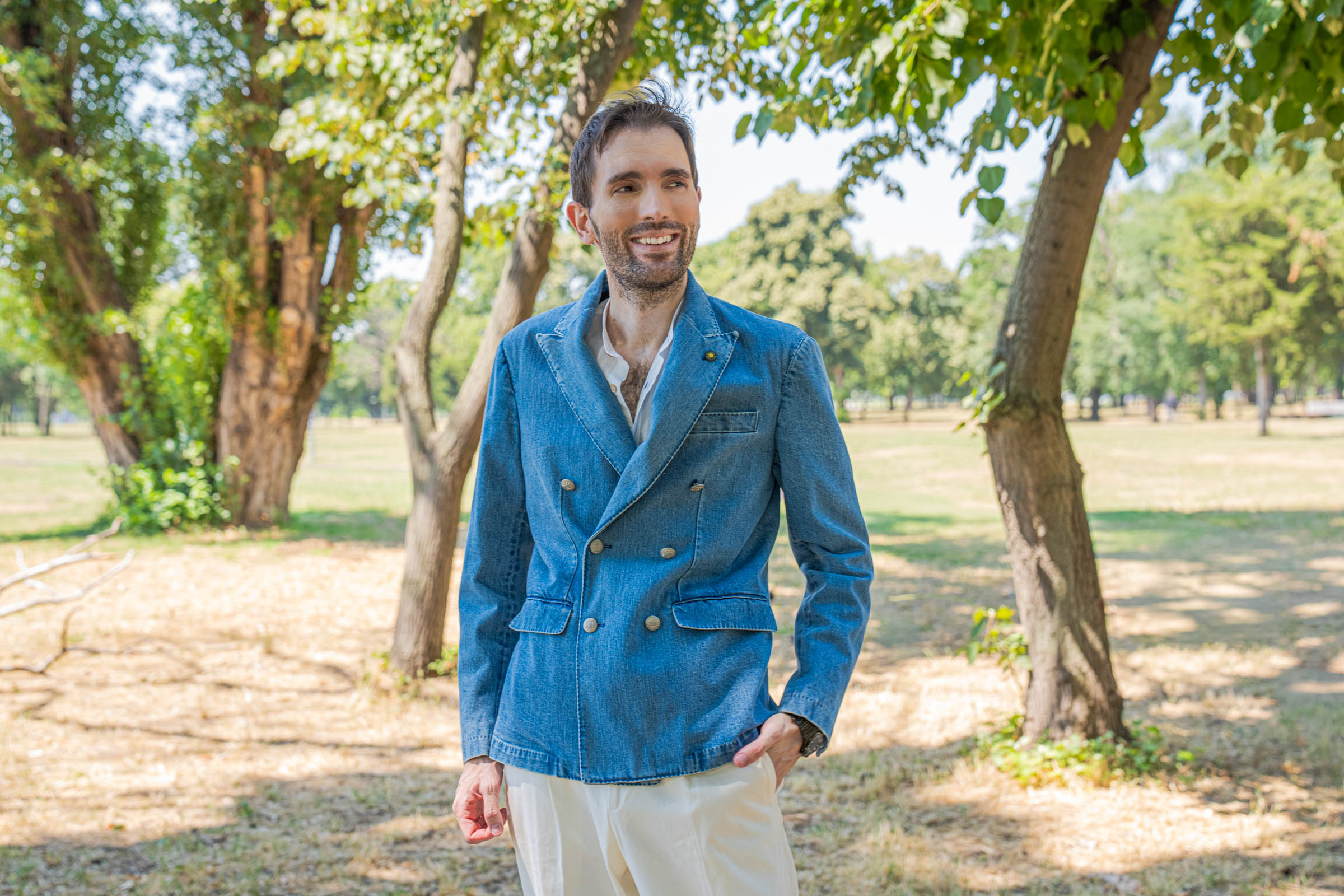 Portrait of a smiling Marko Tadić wearing the Giannetto Portofino limited edition double-breasted denim jacket open over a white mandarin collar shirt