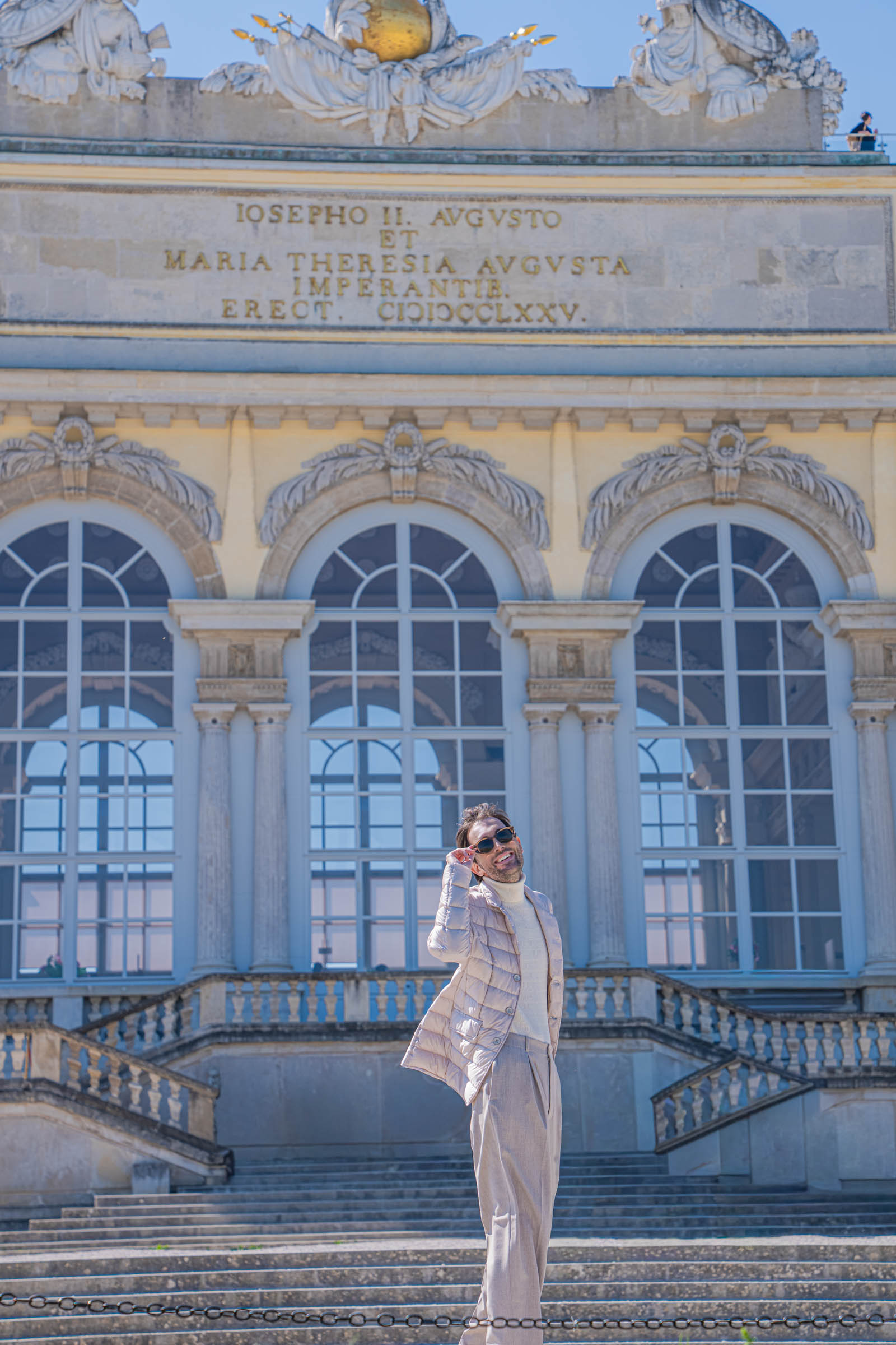 Side profile of Marko Tadić, founder of the Mr.M blog, in a Herno La Giacca jacket and Armani trousers by the pond below the Gloriette