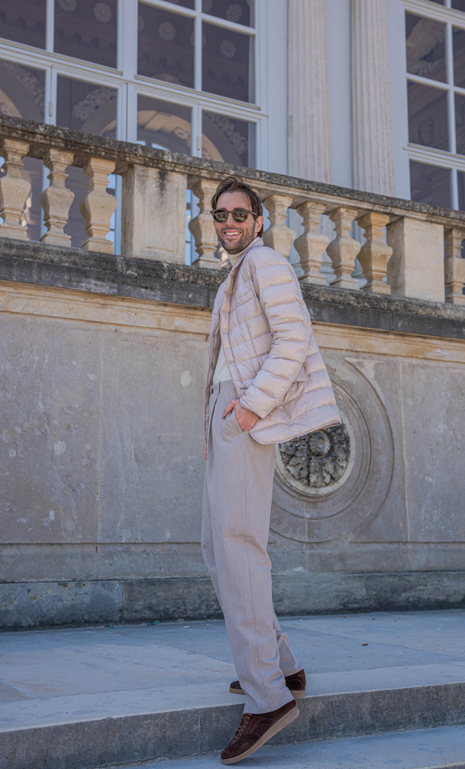 Marko Tadić, founder of the Mr.M blog, in an ivory Giorgio Armani turtleneck in front of the tall arched windows of the Gloriette in Vienna