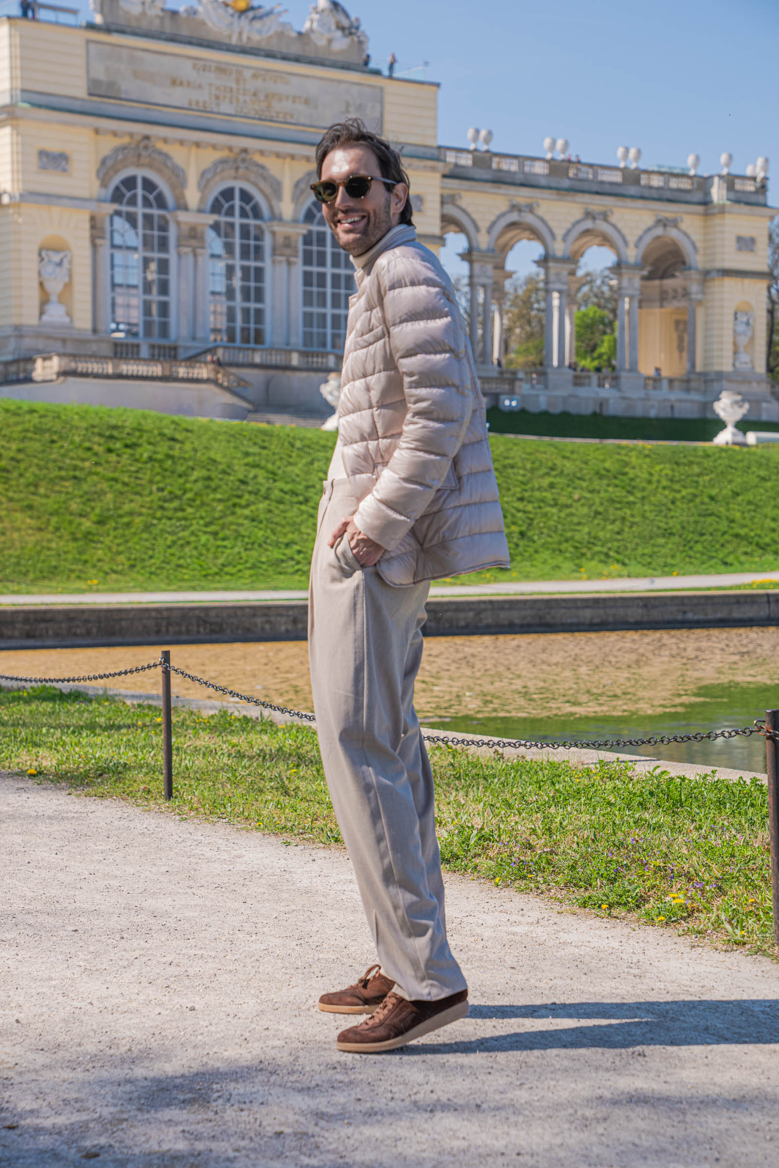 Marko Tadić, founder of the Mr.M blog, glancing back on the gravel path with the Gloriette and Schönbrunn gardens behind him