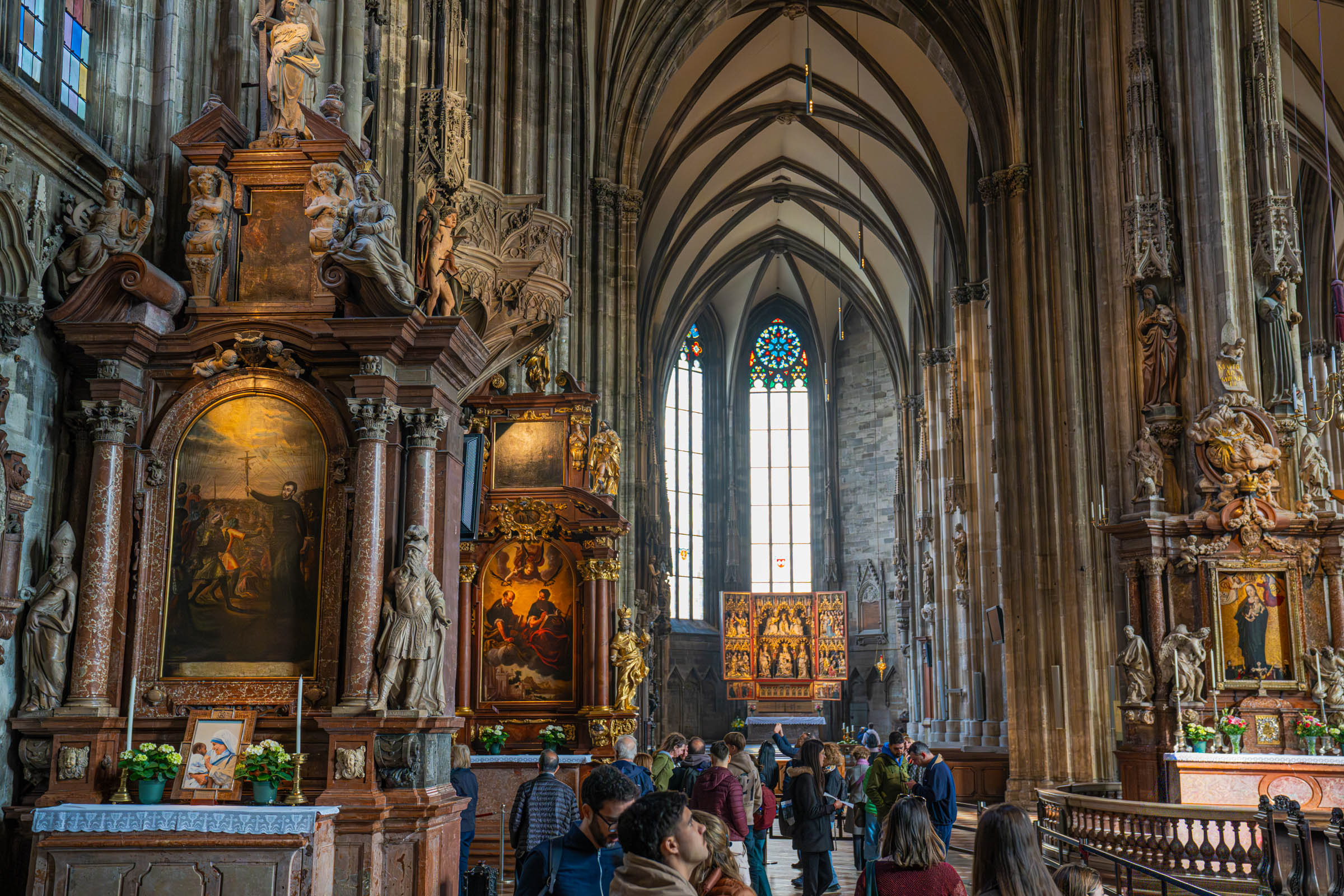 Ornate baroque side altars and stained glass inside St. Stephen's Cathedral, Vienna's Gothic landmark