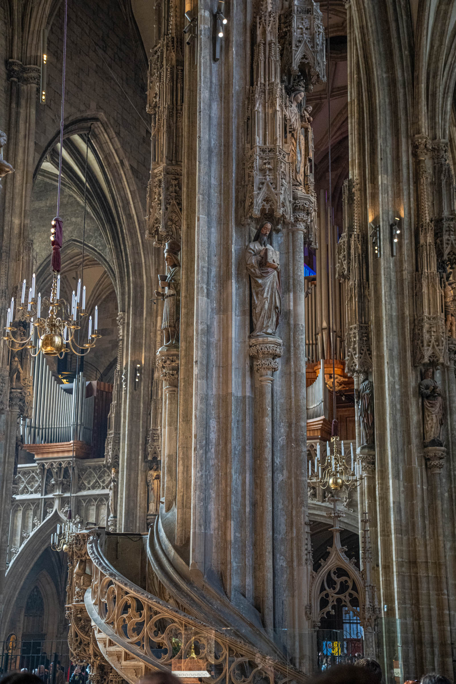 Gothic stone pillars with medieval statues and organ pipes inside St. Stephen's Cathedral in Vienna, Austria