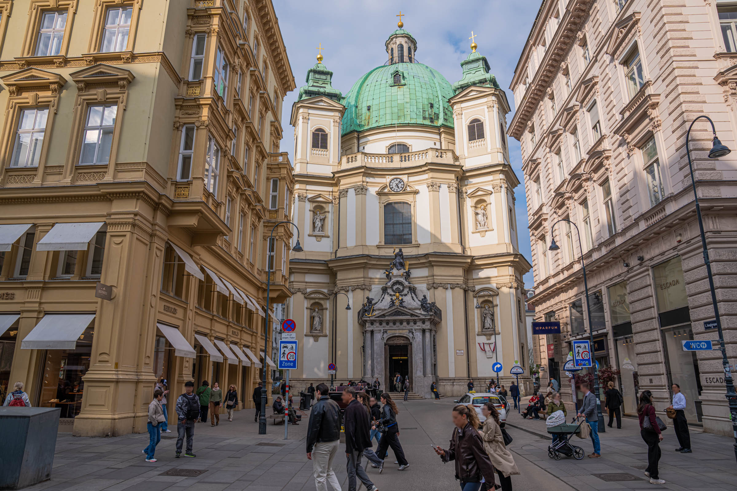 Green dome of St. Peter's Church framed by elegant buildings near Graben in Vienna's historic center