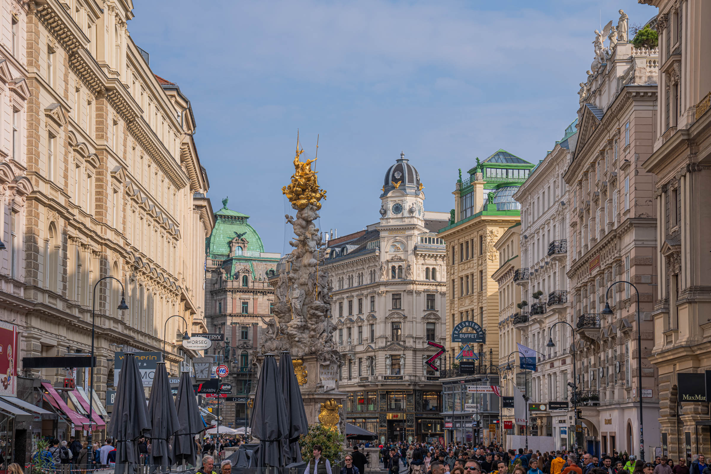 Gilded top of the Vienna Plague Column glowing in evening light on Graben boulevard, Austria