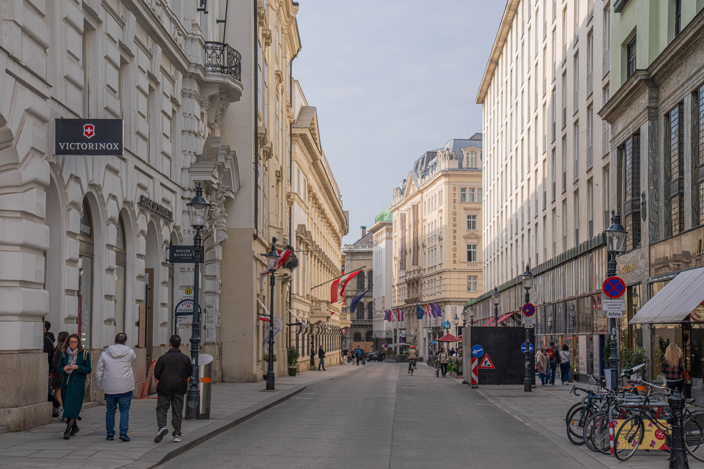 Elegant street in Vienna's first district with Austrian flags leading toward the Hofburg quarter