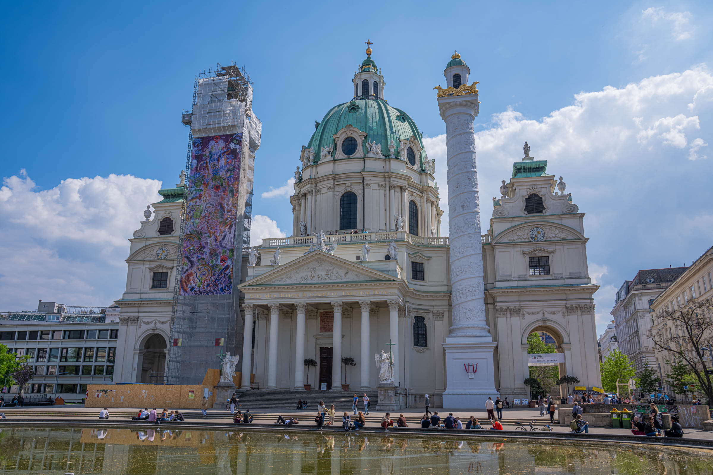 Karlskirche Vienna, the baroque St. Charles Church with green dome and columns mirrored in the pond