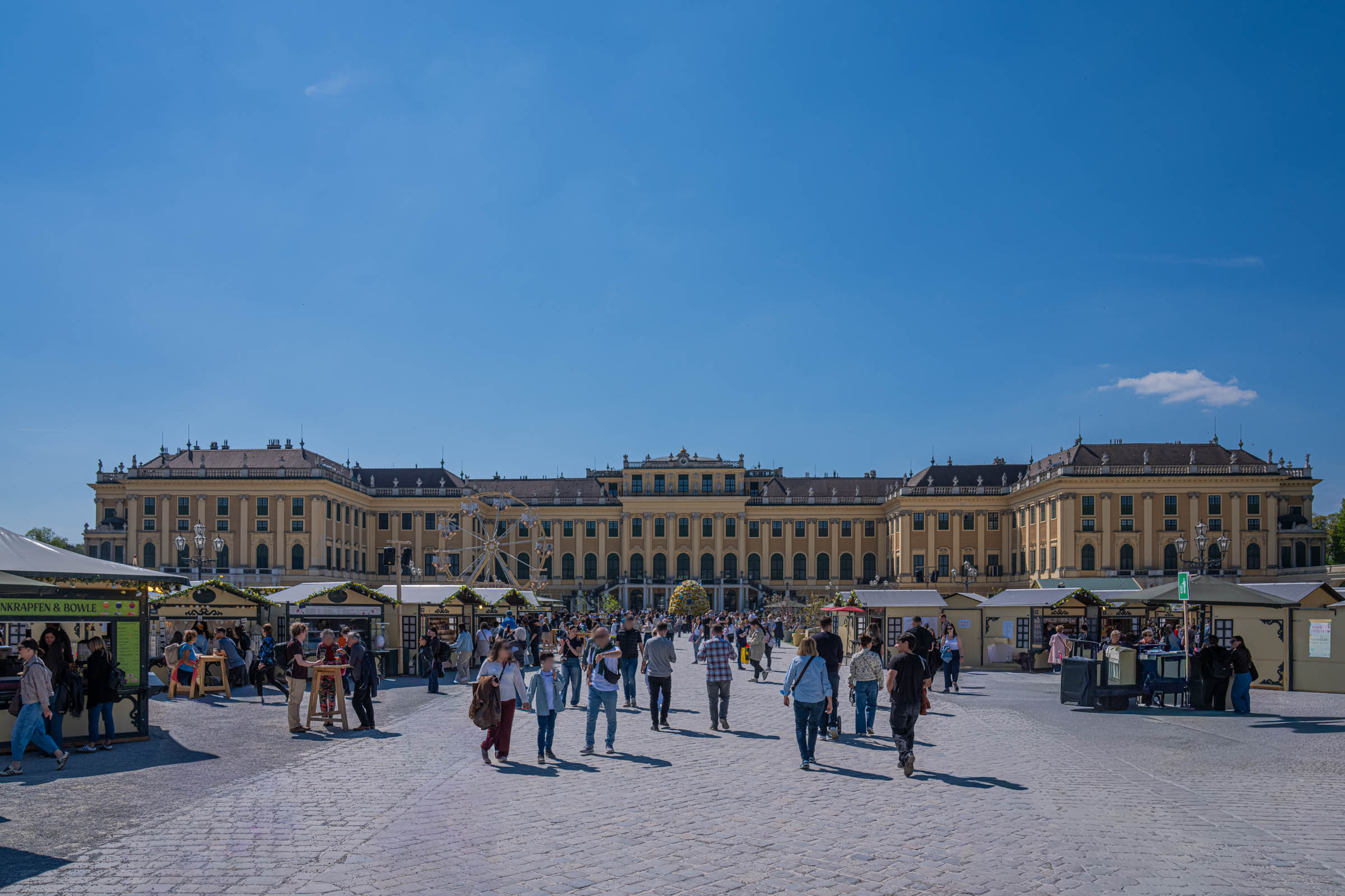 Easter market stalls and ferris wheel in the grand forecourt of Schönbrunn Palace, Vienna, Austria