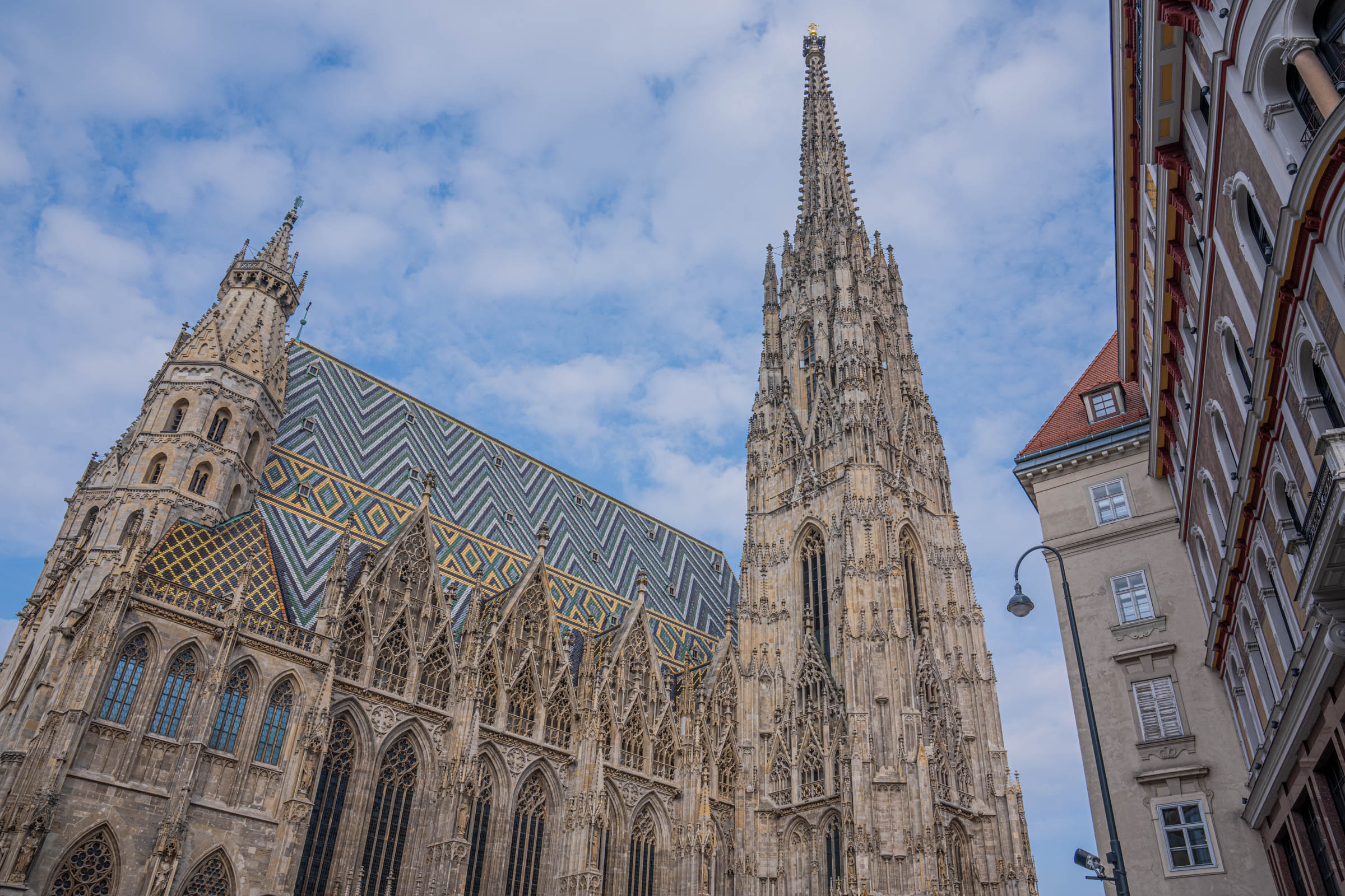 St. Stephen's Cathedral Vienna with its iconic colorful tiled roof and Gothic south tower against a blue sky
