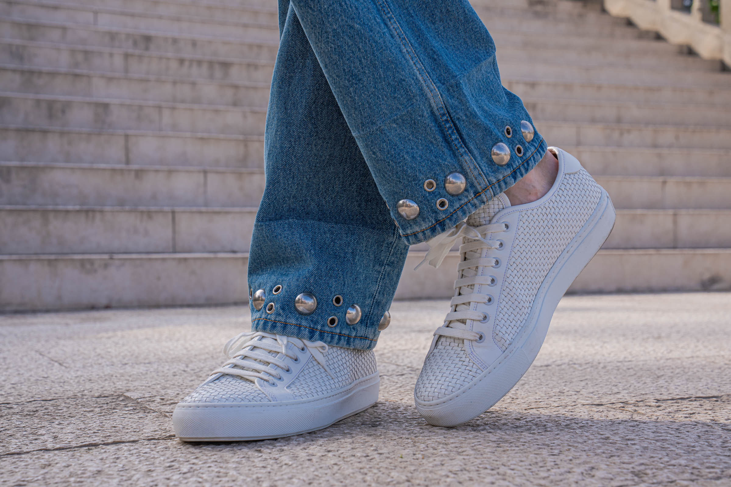 Valentino woven leather sneakers beside the studded denim hem, worn by Marko Tadić